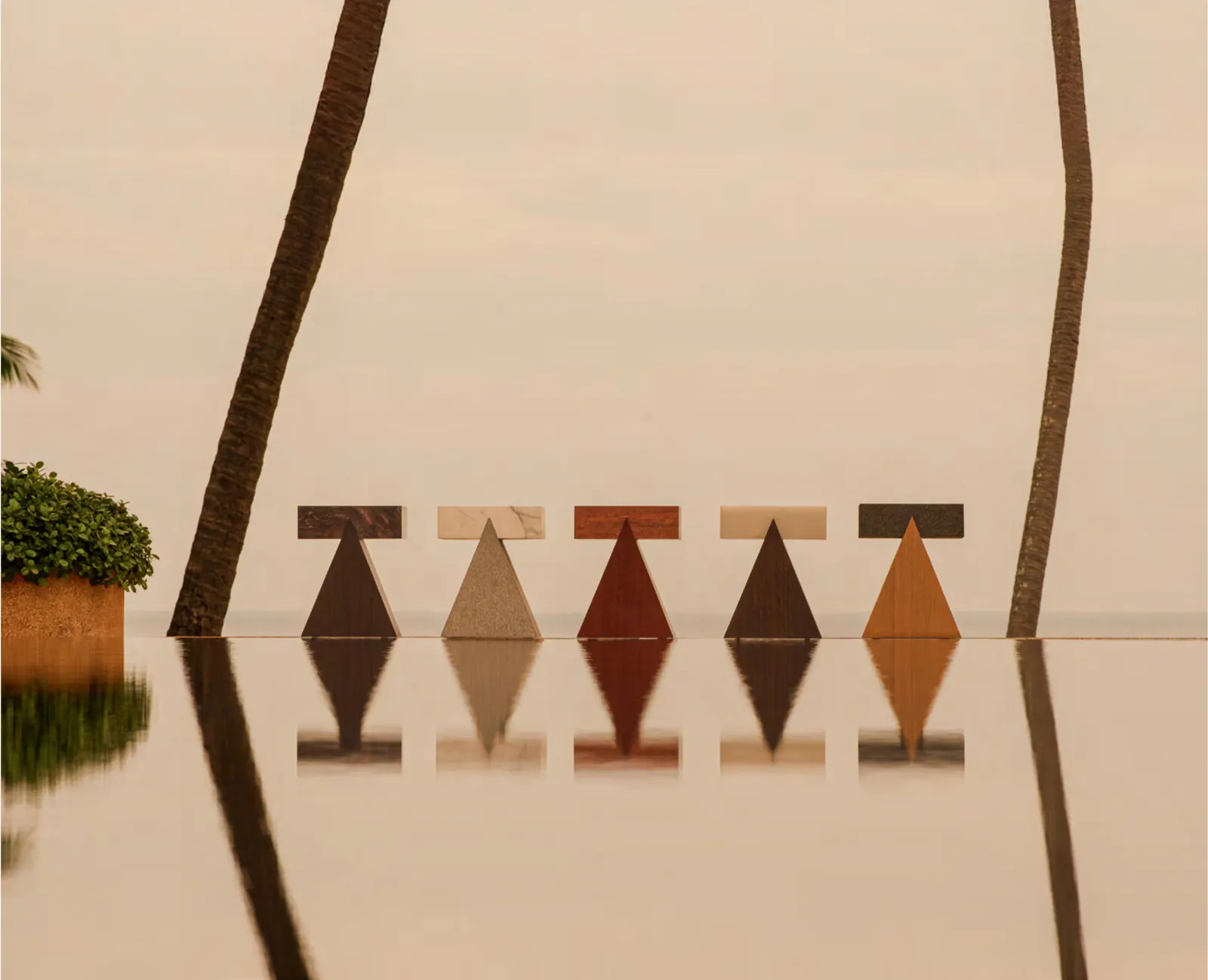 Aman Interiors sculptural stools in stone and timber reflected in still water